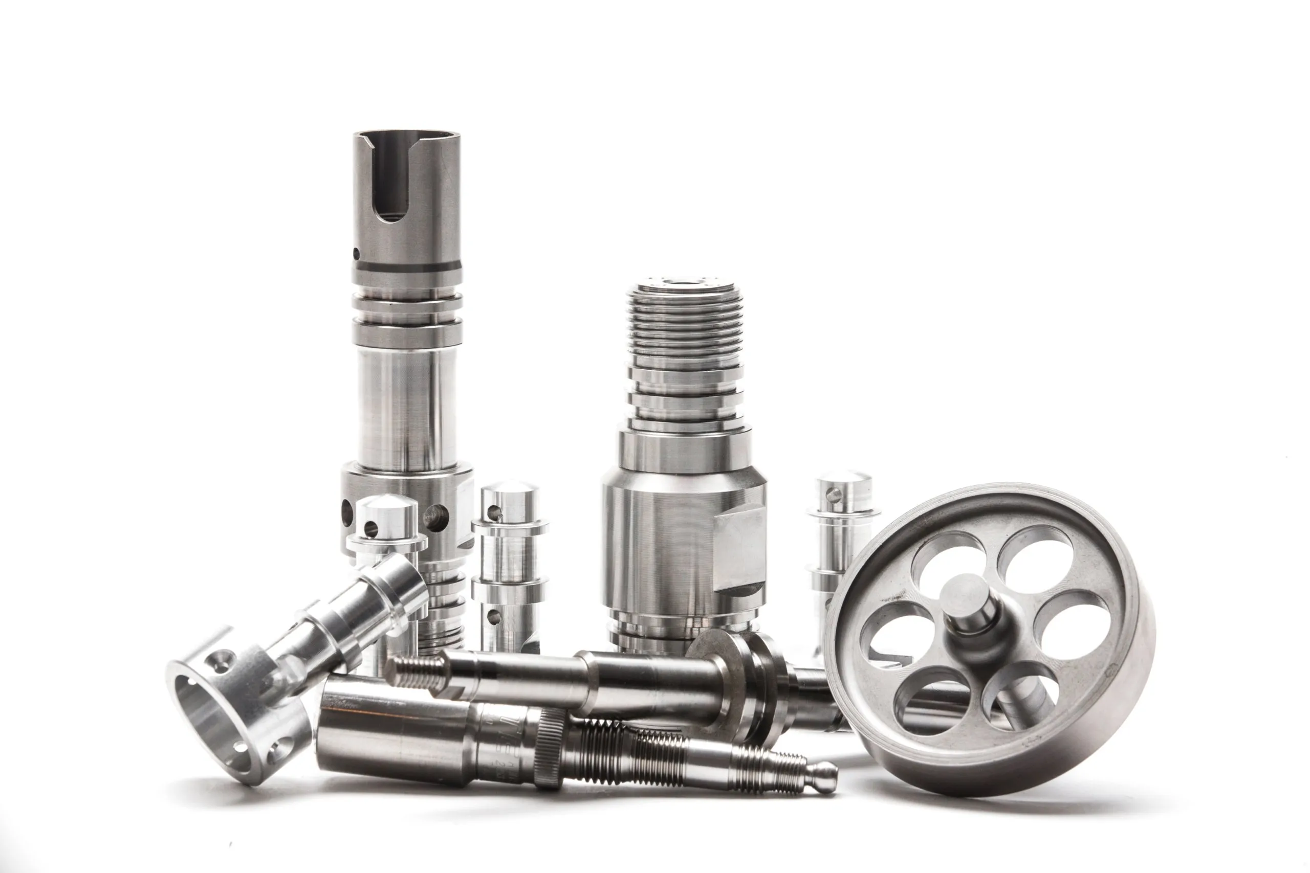 An assortment of machined steel parts on white