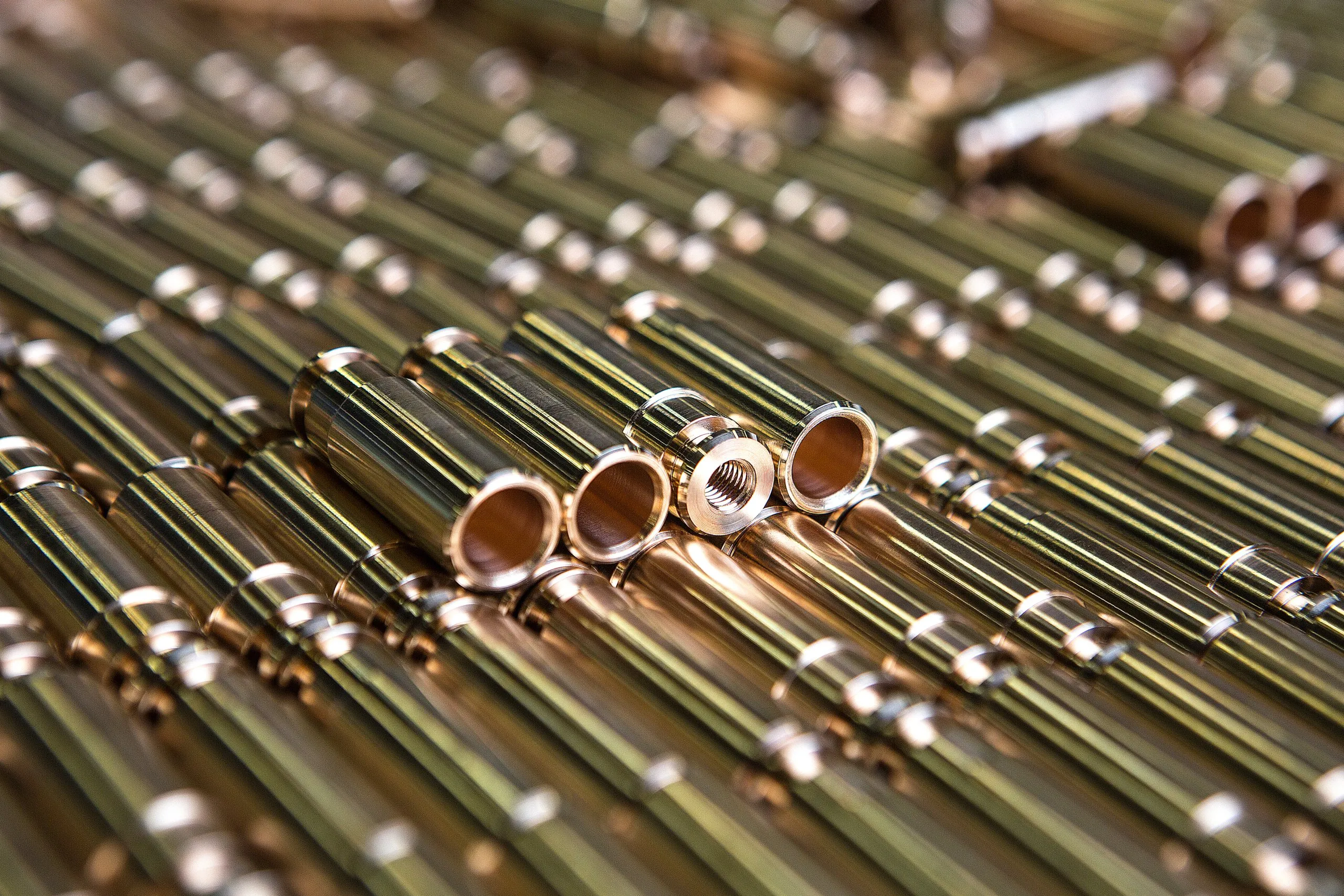 Copper-coloured tubes and brass rods laid side by side