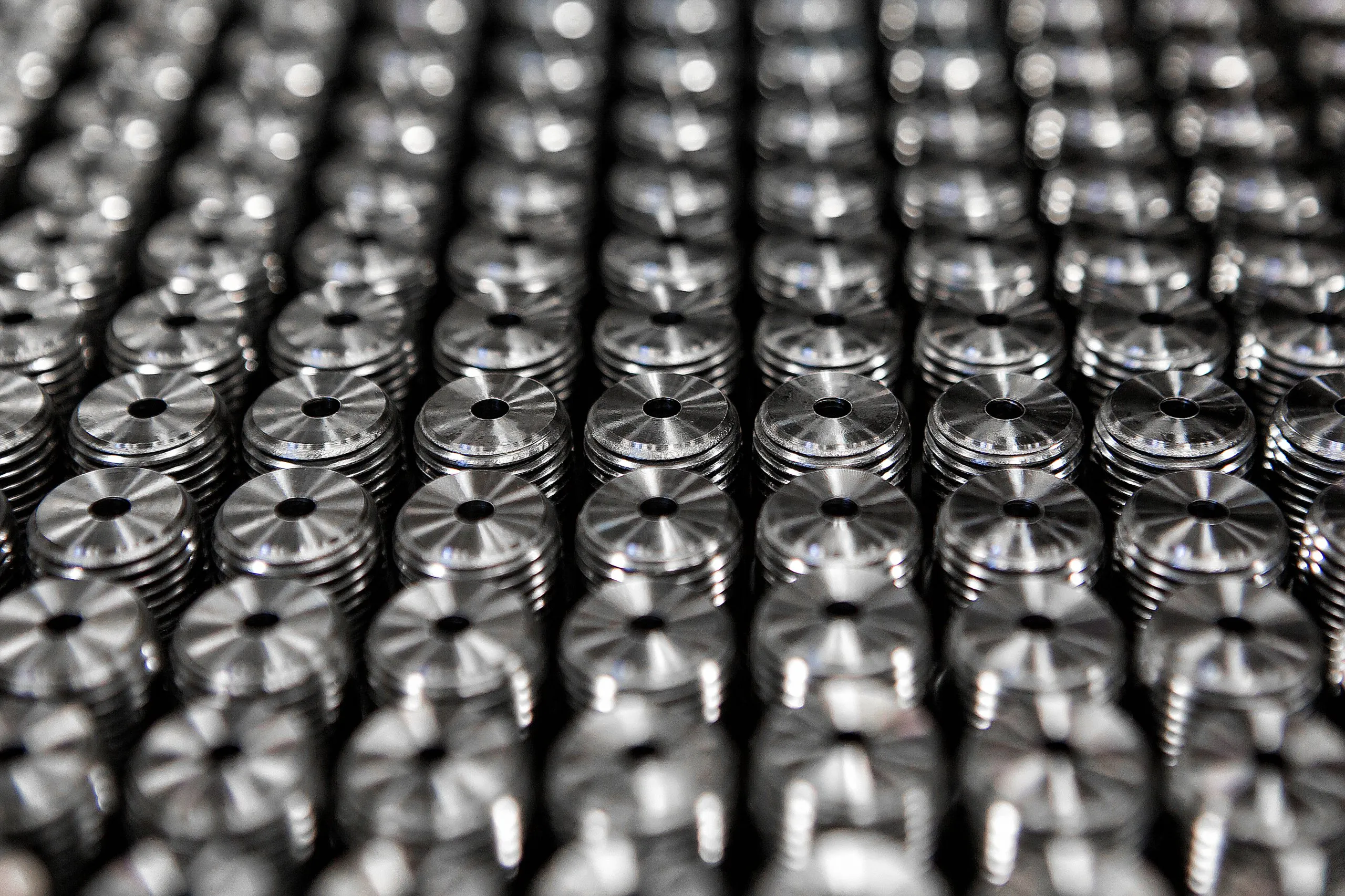 A tray of identical machined parts arranged in tight rows