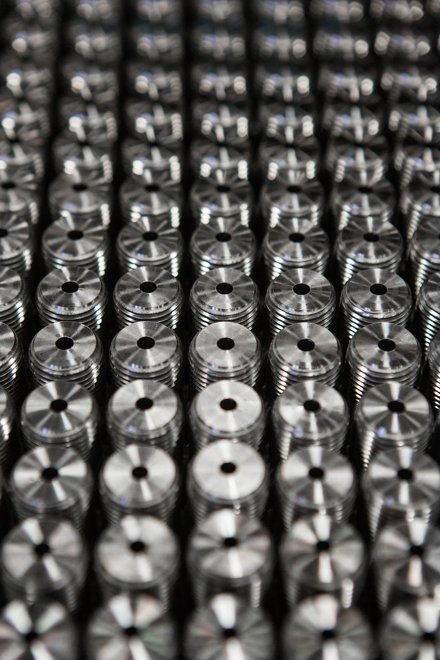 Rows of machined parts receding into soft focus